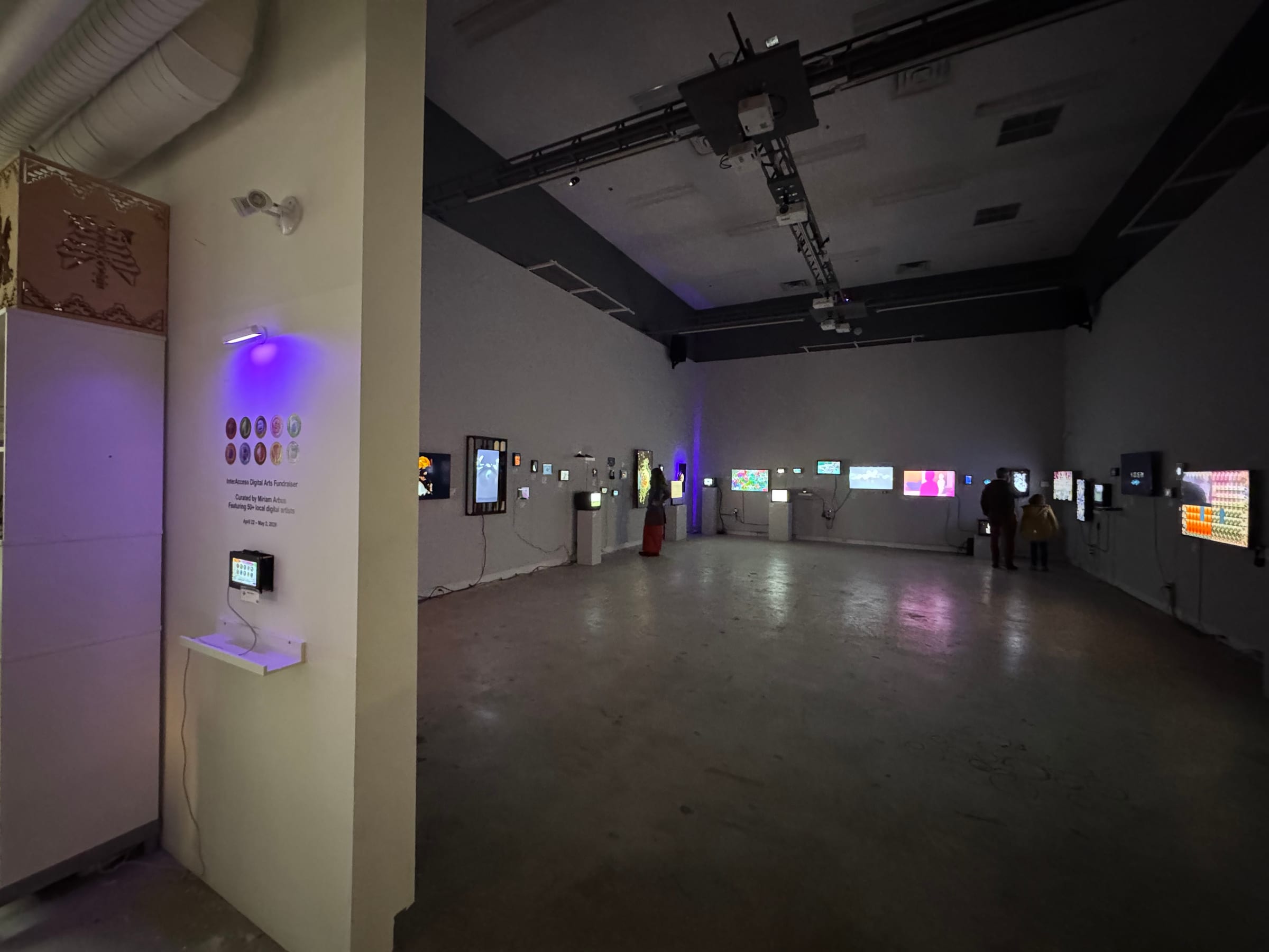 Installation view of flashDRIVE 2026 at InterAccess, Toronto, with works on screens around the gallery