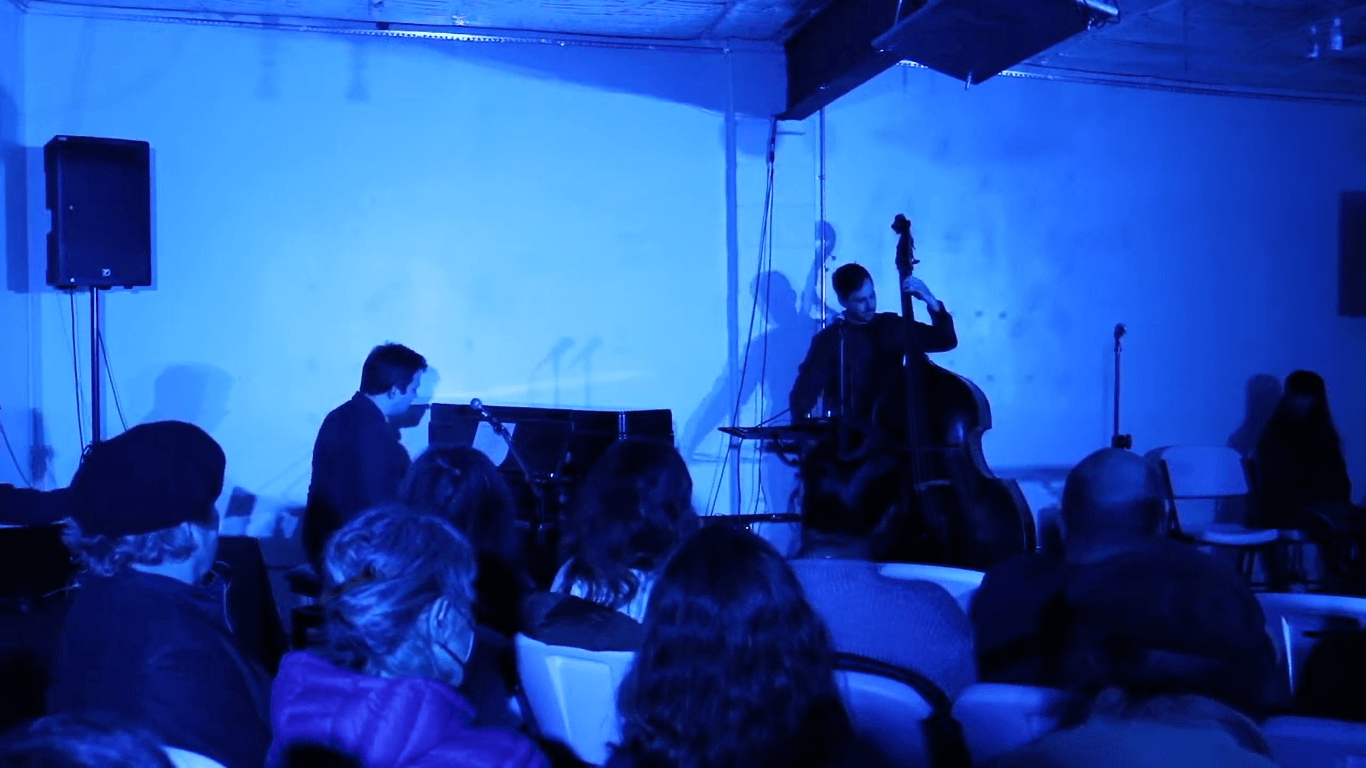 Musicians performing under blue light for an audience at Silence, Guelph