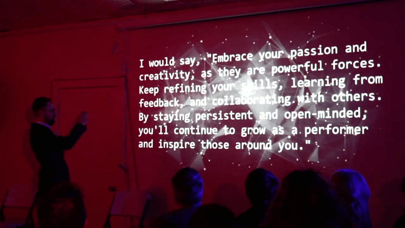 Text from the AI ARIA projected over a performer in red light: “Embrace your passion and creativity…”
